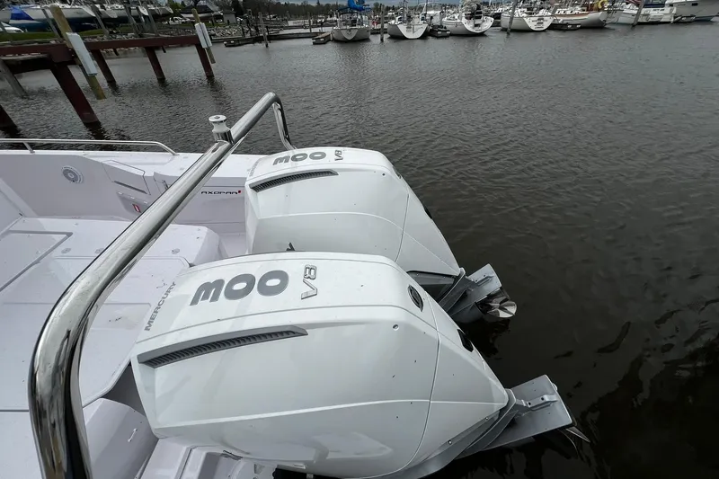 Slide: The Image of 2025 Axopar 37 XC Cross Cabin with twin Mercury V8 engines docked at marina. - 2