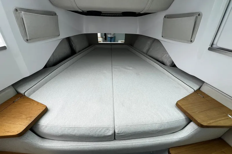 Slide: The Image of 2025 Axopar 37 XC Cross Cabin interior with spacious bed and wooden side tables. - 22