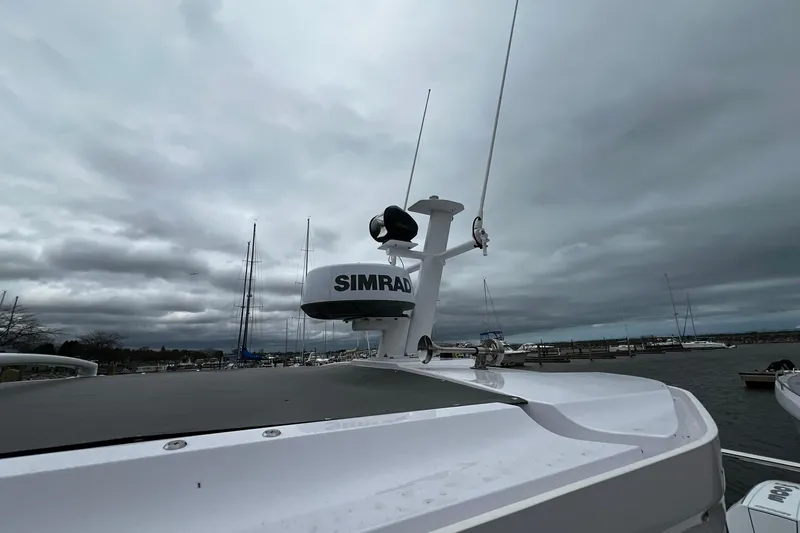 Slide: The Image of 2025 Axopar 37 XC Cross Cabin with Simrad radar, docked under cloudy skies. - 25