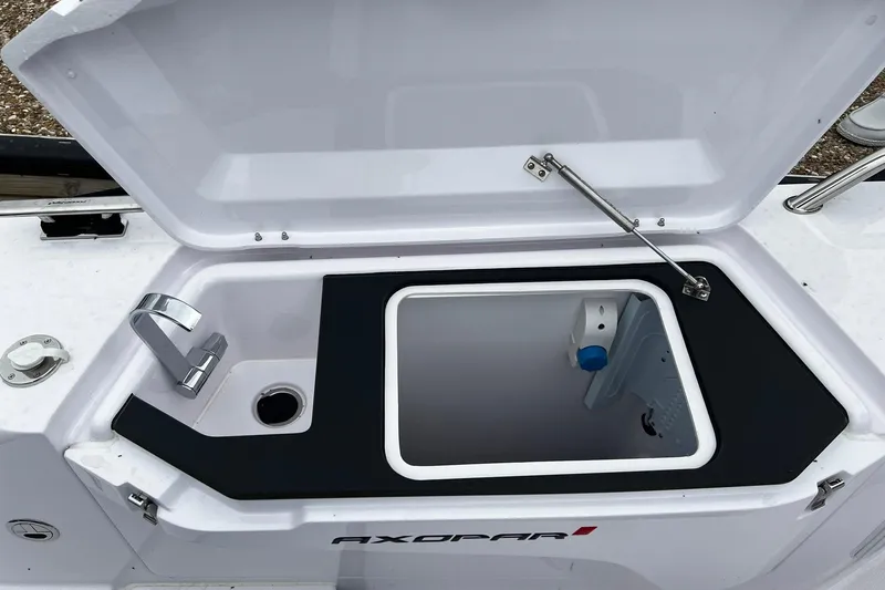 Slide: The Image of Open storage compartment with sink on 2025 Axopar 37 XC Cross Cabin boat. - 26