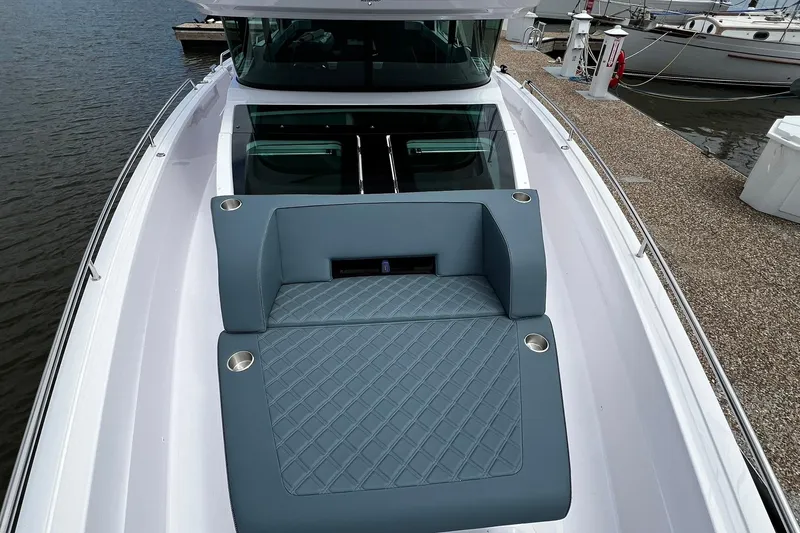 Slide: The Image of 2025 Axopar 37 XC Cross Cabin boat with cushioned deck seating at the marina. - 4