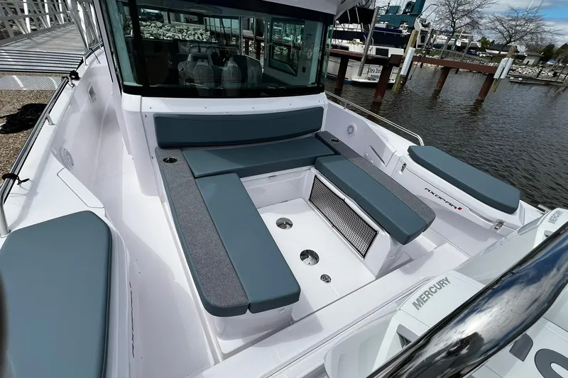 Slide: The Image of 2025 Axopar 37 XC Cross Cabin boat with spacious seating and modern design at a marina. - 5