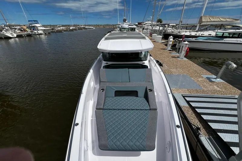 Slide: The Image of 2025 Axopar 37 XC Cross Cabin docked at marina, showcasing sleek design and spacious deck. - 8