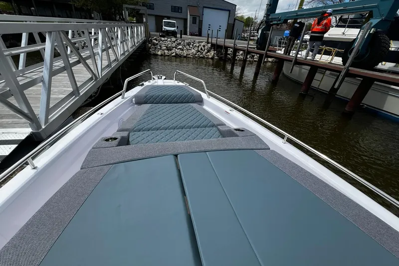 Slide: The Image of 2025 Axopar 37 XC Cross Cabin boat docked, featuring sleek deck design and modern upholstery. - 9