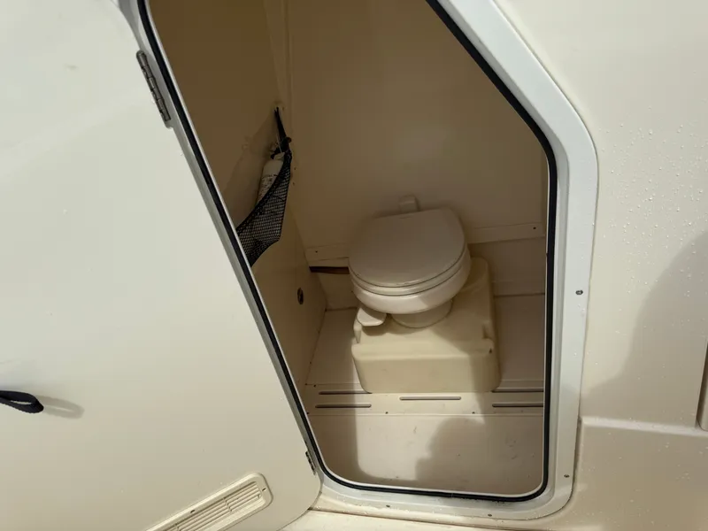 Slide: The Image of The image shows a small boat toilet in a compact space with a door. - 15