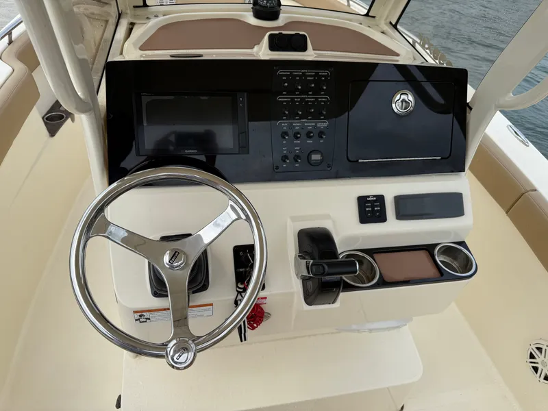 Slide: The Image of The image shows the helm of a 2020 Scout 235 XSF boat with a steering wheel and instruments. - 11