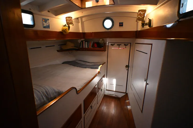 Slide: The Image of Cozy 1963 Rhodes 50 yacht cabin with wooden interior and porthole window. - 24