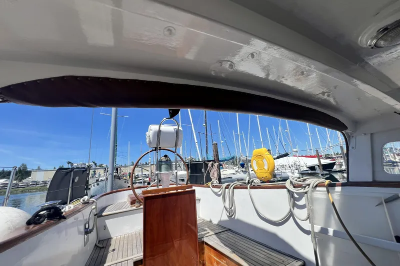 Slide: The Image of 1963 Rhodes 50 sailboat cockpit with marina view, featuring ropes and life preserver. - 6