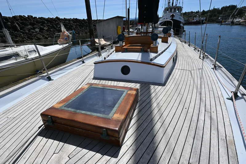 Slide: The Image of 1963 Rhodes 50 sailboat deck with wooden details, docked in a marina. - 17