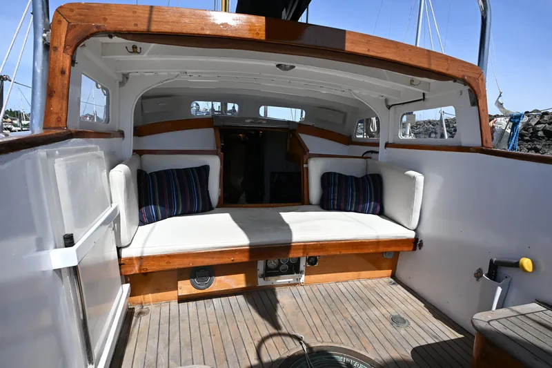 Slide: The Image of 1963 Rhodes 50 sailboat interior with cushioned seating and striped pillows. - 5