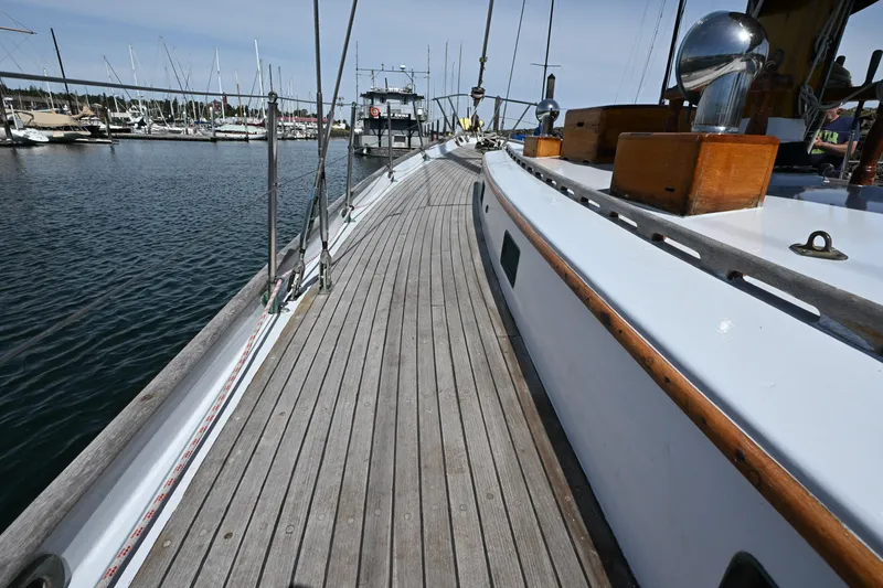 Slide: The Image of Deck view of a 1963 Rhodes 50 sailboat docked in a marina. - 13