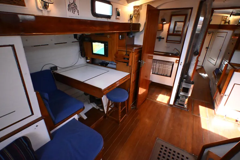 Slide: The Image of Interior of a 1963 Rhodes 50 sailboat with wooden furnishings and a navigation station. - 23