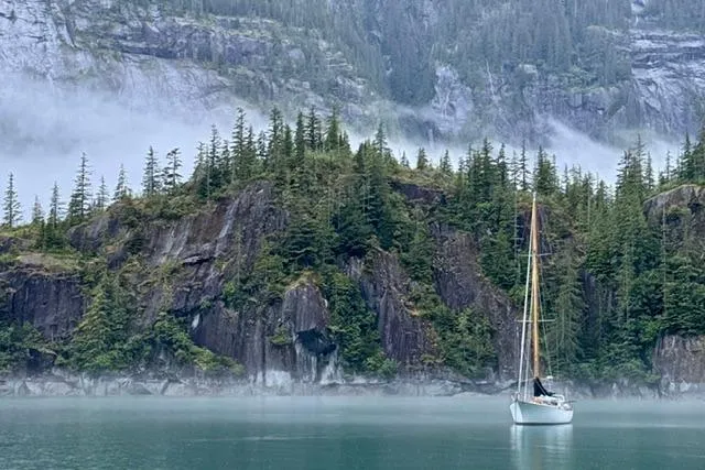 Slide: The Image of Sailboat "Rhodes 50 Cutter" (1963) on misty lake with forested cliffs. - 55