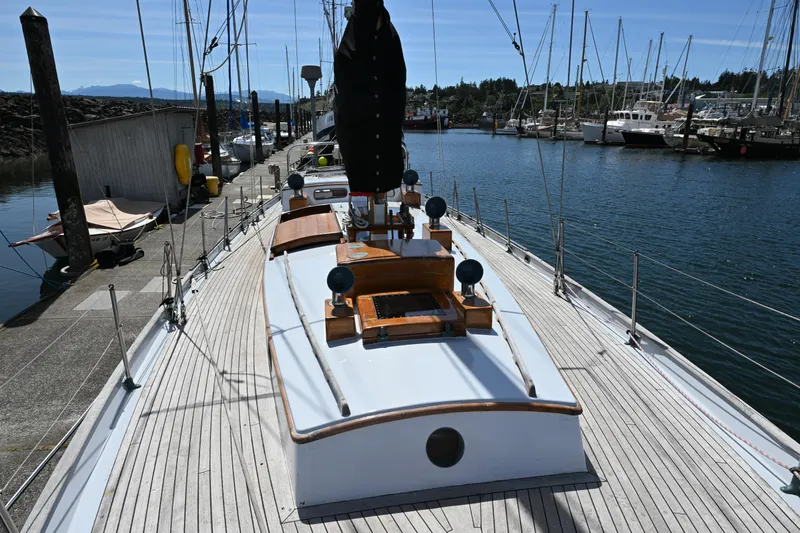 Slide: The Image of Vintage 1963 Rhodes 50 sailboat docked at a marina under clear blue skies. - 16