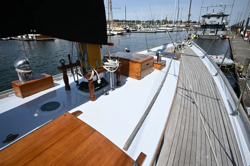 Slide: The Image of Vintage 1963 Rhodes 50 sailboat docked at marina, showcasing wooden deck and classic design. - 12