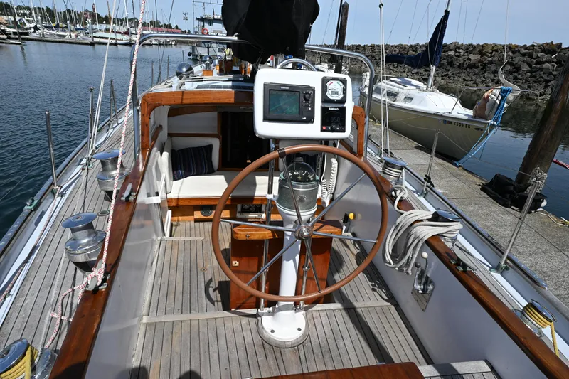 Slide: The Image of Cockpit of a 1963 Rhodes 50 sailboat with wooden accents and navigation equipment. - 8
