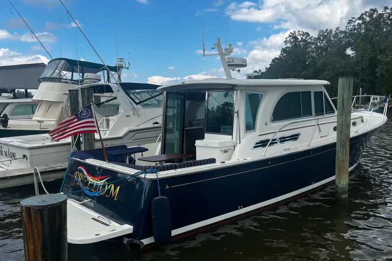 Slide: The Image of 2018 Back Cove 41 yacht docked, featuring sleek design and American flag. - 5