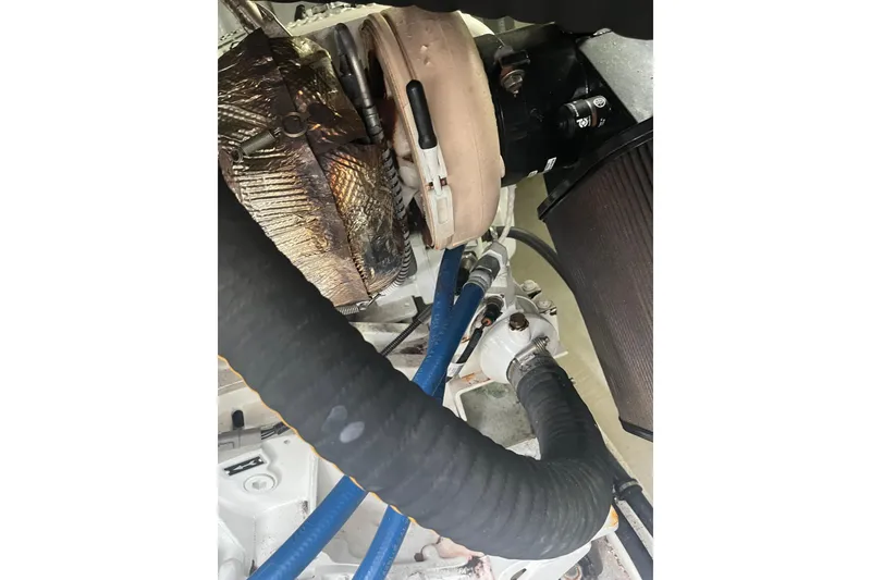 Slide: The Image of Engine components of a 2018 Back Cove 41 boat, featuring hoses and metal parts. - 21