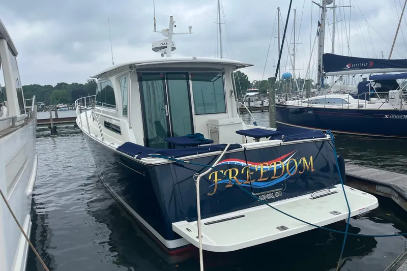 Slide: The Image of 2018 Back Cove 41 boat named "Freedom" docked at a marina. - 0
