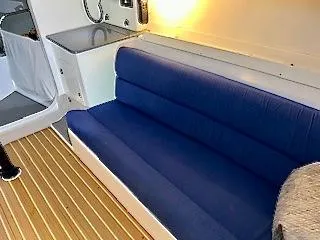 Slide: The Image of Interior of the 2015 J/88 with a blue cushioned bench and wooden flooring. - 13
