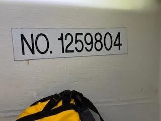 Slide: The Image of A yellow backpack sits next to a wall labeled "NO. 1259804." - 14