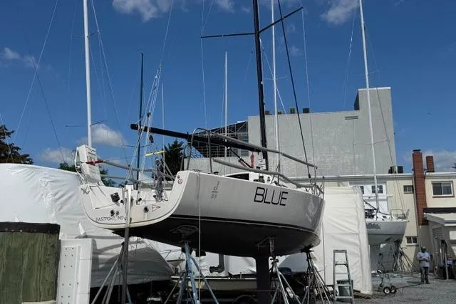 Slide: The Image of 2015 J Boats J/88 sailboat named "BLUE" on dry dock under clear sky. - 7