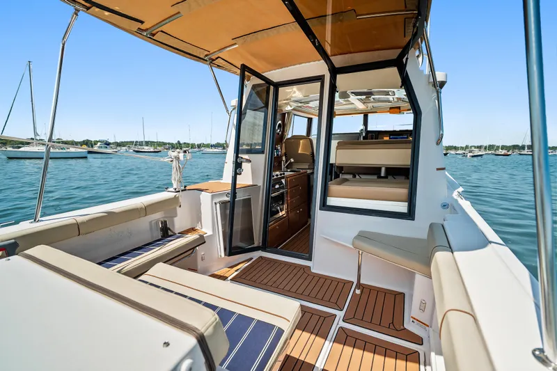 Slide: The Image of 2024 Ranger Tugs R-27 boat interior with seating and open water view. - 24
