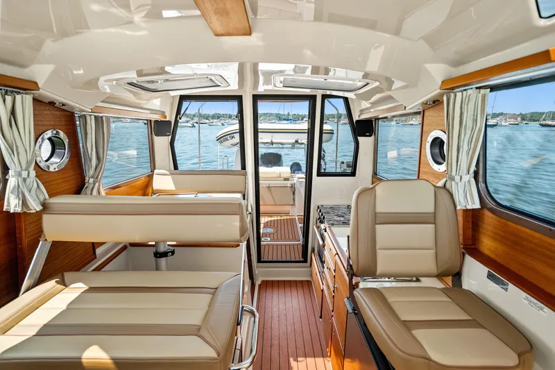Slide: The Image of Interior of 2024 Ranger Tugs R-27 boat with elegant seating and wood accents. - 18