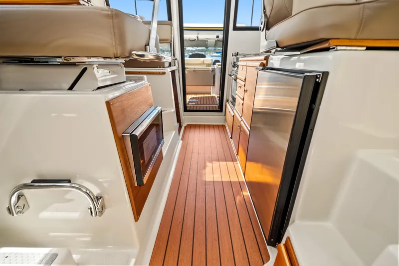 Slide: The Image of Interior of 2024 Ranger Tugs R-27 boat with wood flooring and modern amenities. - 19