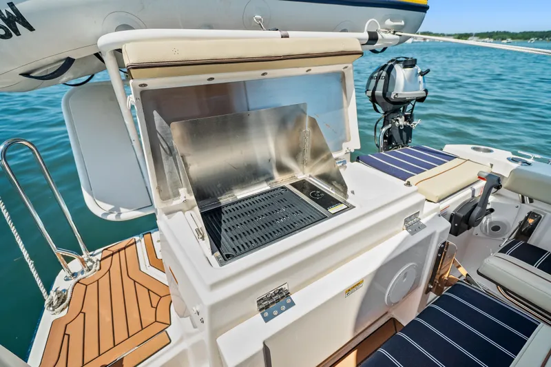 Slide: The Image of 2024 Ranger Tugs R-27 boat with outdoor grill and seating on deck. - 25