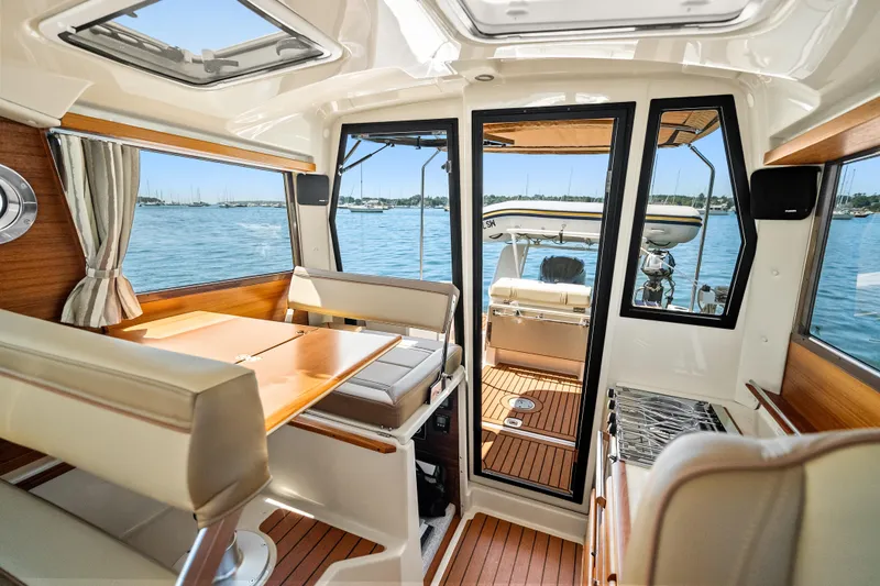 Slide: The Image of Interior of 2024 Ranger Tugs R-27 boat with elegant seating and scenic water view. - 16