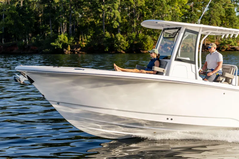 Slide: The Image of 2026 Sea Hunt Ultra 275 Coffin Box cruising on a serene lake with passengers. - 10