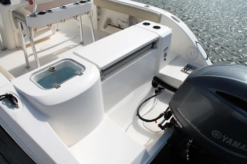 Slide: The Image of 2018 Cobia 220 Center Console boat interior with Yamaha engine and fishing setup. - 11