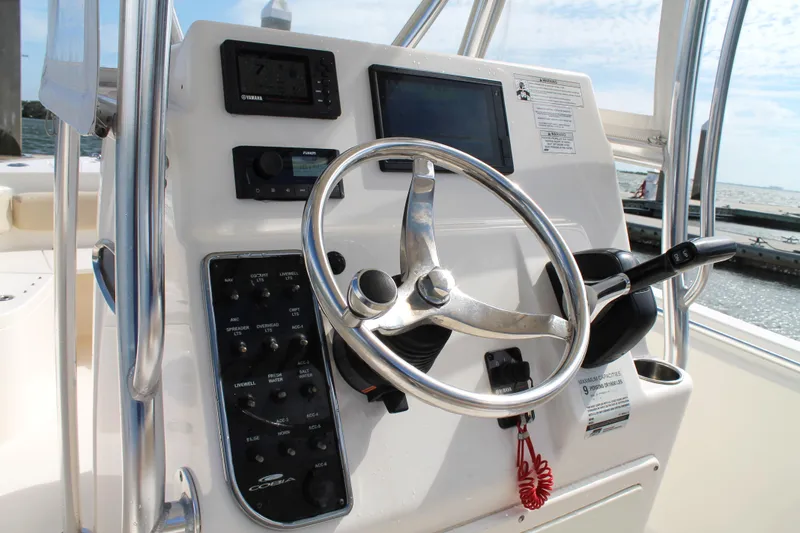 Slide: The Image of 2018 Cobia 220 Center Console boat dashboard with steering wheel and controls. - 14