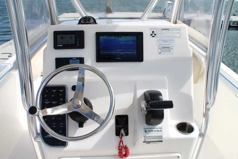 Slide: The Image of 2018 Cobia 220 Center Console boat dashboard with steering wheel and navigation controls. - 15