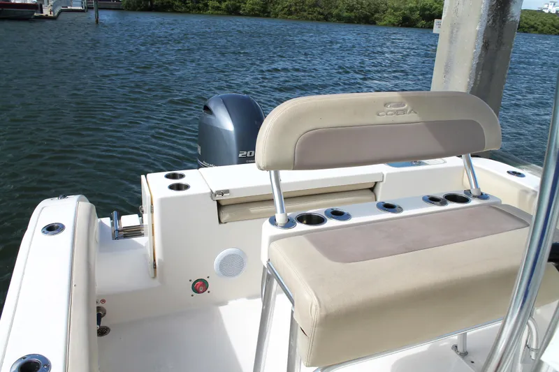 Slide: The Image of 2018 Cobia 220 Center Console boat with seating and outboard motor on the water. - 16