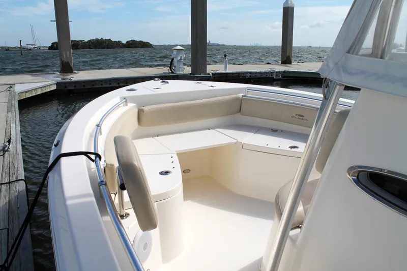 Slide: The Image of 2018 Cobia 220 Center Console boat docked, featuring spacious seating and open deck. - 20
