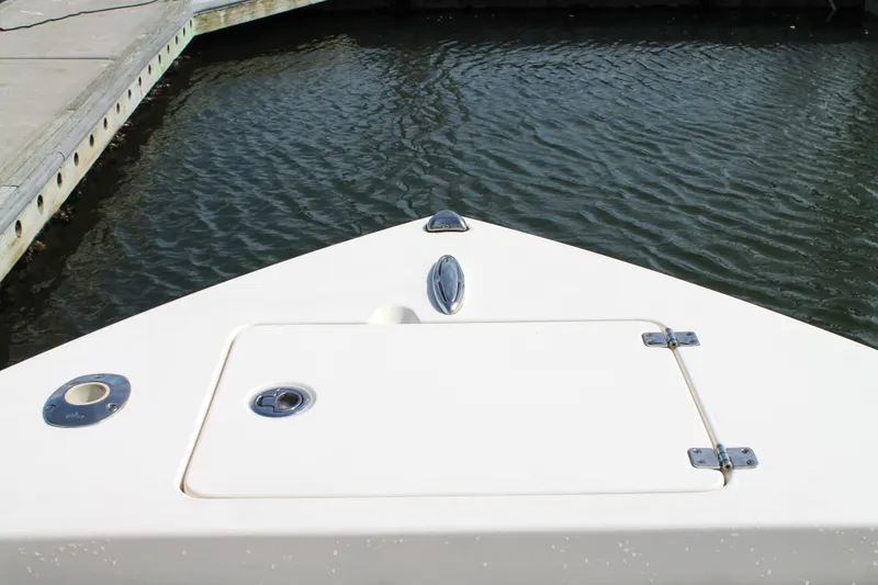 Slide: The Image of Bow of 2018 Cobia 220 Center Console boat docked by the water. - 24
