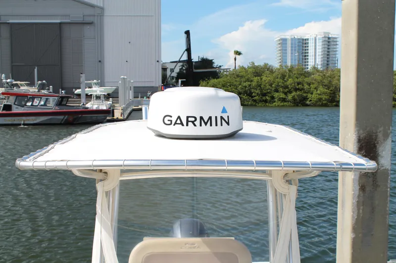 Slide: The Image of 2018 Cobia 220 Center Console boat with Garmin radar, docked near waterfront buildings. - 26