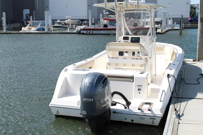 Slide: The Image of 2018 Cobia 220 Center Console boat docked with Yamaha outboard motor. - 4