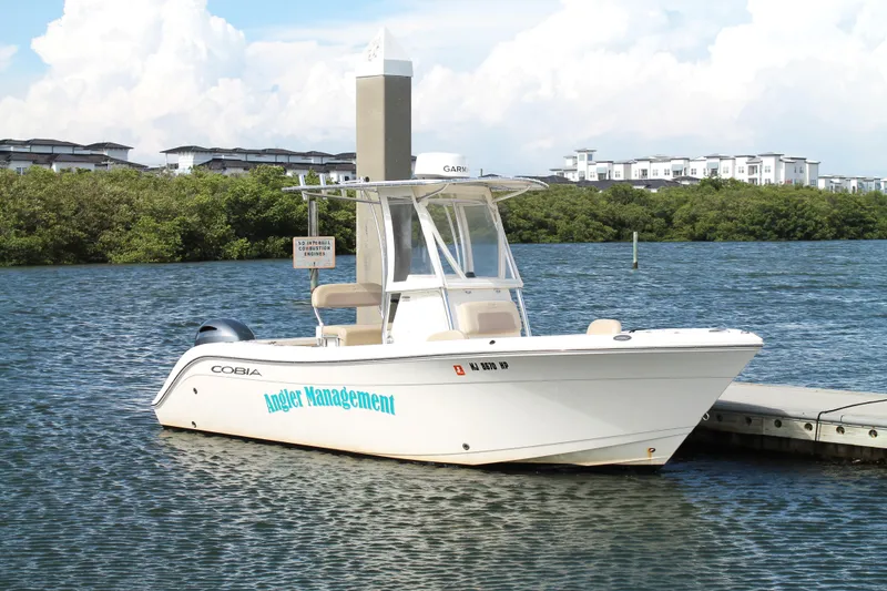 Slide: The Image of 2018 Cobia 220 Center Console boat docked on a sunny day. - 6