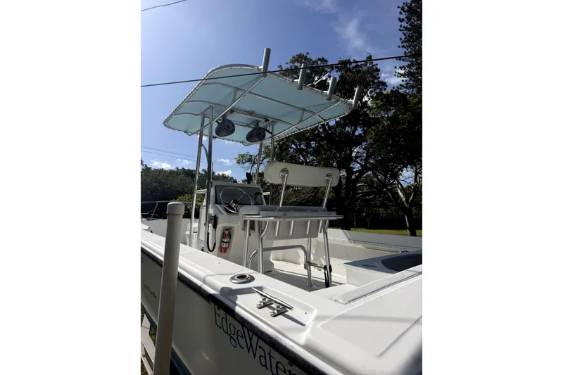 Slide: The Image of 1999 Edgewater 200CC boat with T-top, console, and seating, under clear blue sky. - 13