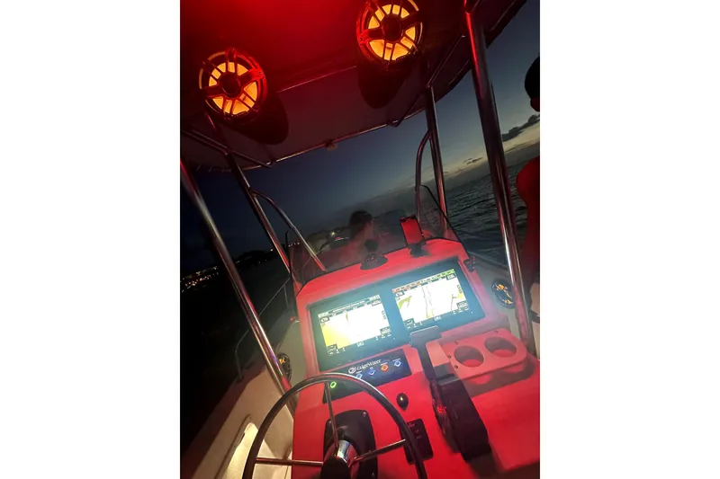 Slide: The Image of Edgewater 200CC boat cockpit at dusk with illuminated navigation screens. - 14
