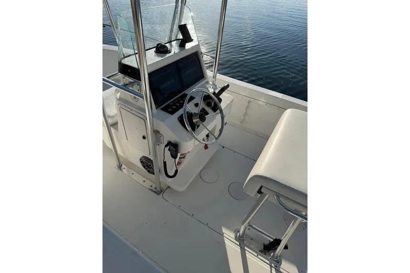 Slide: The Image of 1999 Edgewater 200CC boat console with steering wheel and Garmin displays on calm water. - 3