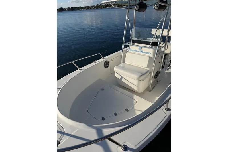 Slide: The Image of 1999 Edgewater 200CC boat on calm water, featuring a spacious deck and seating area. - 4