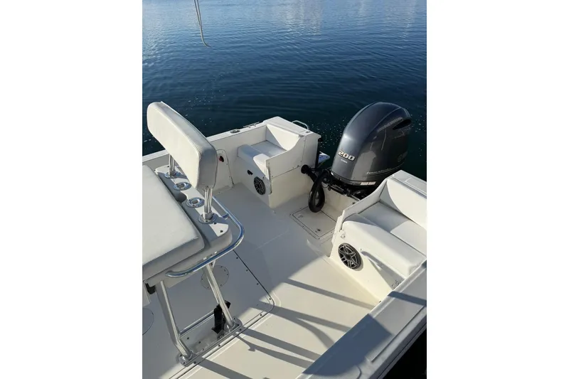 Slide: The Image of 1999 Edgewater 200CC boat interior with seating and outboard motor on calm water. - 5