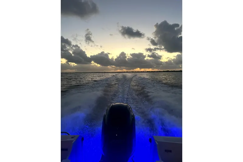 Slide: The Image of Sunset view from a 1999 Edgewater 200CC boat, with illuminated wake and cloudy sky. - 8