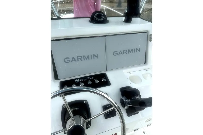 Slide: The Image of Edgewater 200CC 1999 boat dashboard with Garmin navigation displays and steering wheel. - 9