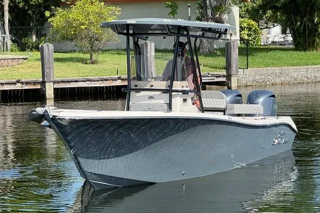 Slide: The Image of 2026 Sea Chaser 24 HFC boat on calm water near a dock, showcasing sleek design. - 9