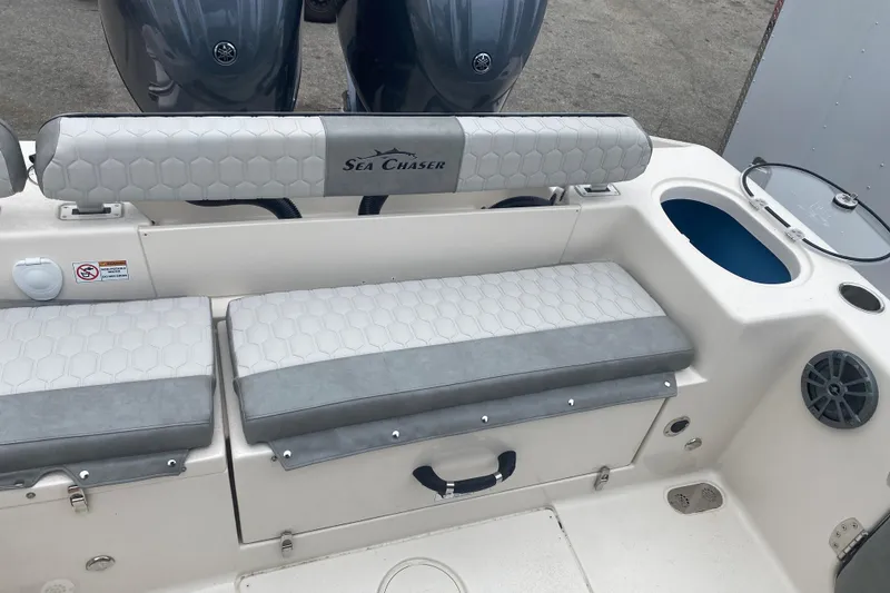 Slide: The Image of 2026 Sea Chaser 24 HFC boat interior with cushioned seating and storage compartments. - 11